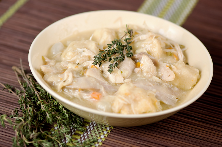 Chicken and dumpling soup with fresh thyme garnish