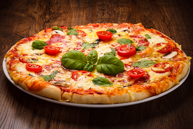 Pizza with tomatoes, cheese, and fresh basil